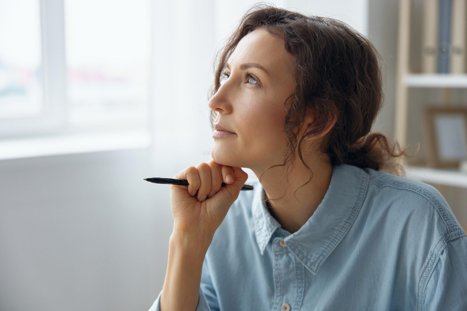 Mujer profesional mirando por la ventana en una etapa de cambio